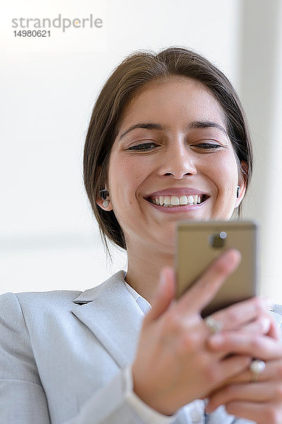 Geschäftsfrau liest gute Nachrichten auf Smartphone