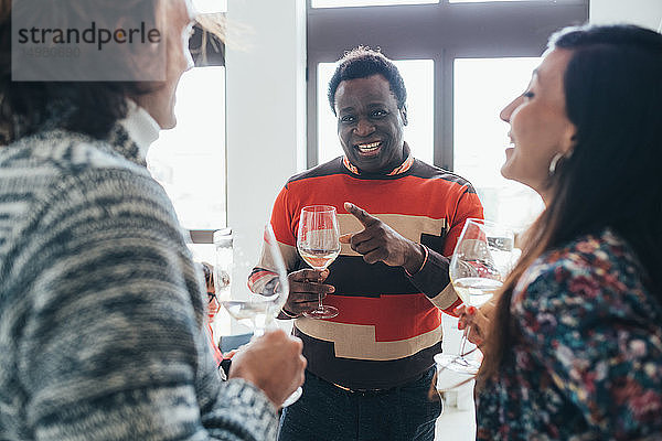 Freunde unterhalten sich auf einer Party im Loft-Büro