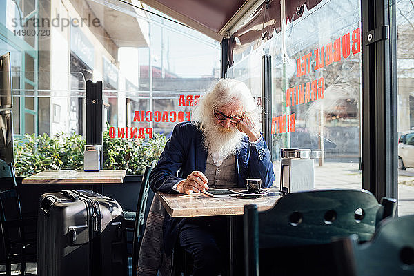 Leitender Geschäftsmann benutzt digitales Tablet in einem Café  Mailand  Lombardei  Italien