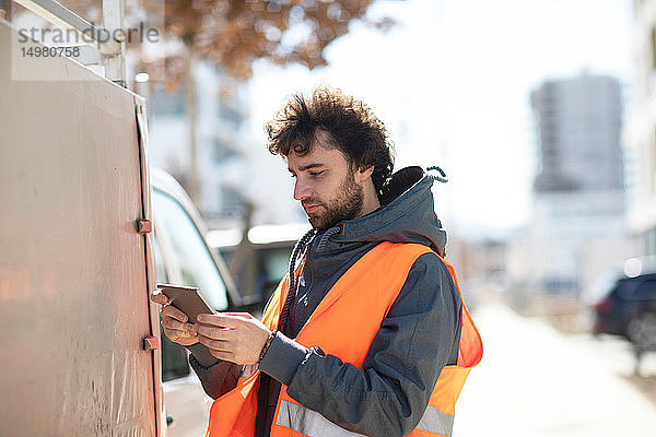 Mann benutzt digitales Tablett auf der Straße