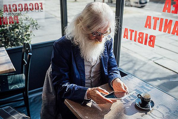 Leitender Geschäftsmann benutzt digitales Tablet in einem Café  Mailand  Lombardei  Italien