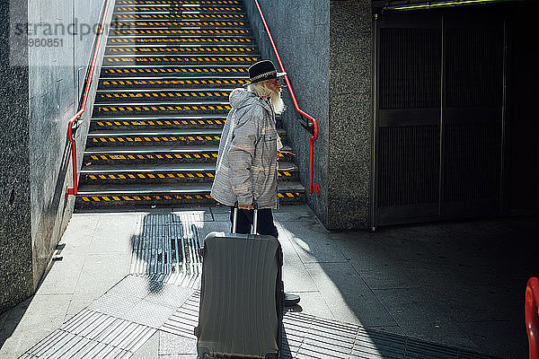 Älterer Mann mit Rollgepäck bei der Einfahrt in die U-Bahn  Mailand  Lombardei  Italien