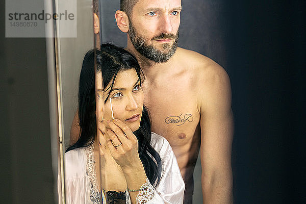 Halbnacktes Hipster-Paar schaut in den Spiegel im Badezimmer