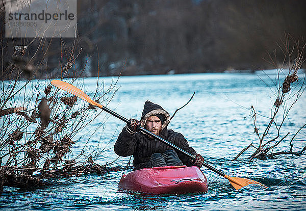 Junger Mann mit Kajak auf dem Fluss im Winter  Porträt  Domodossola  Piemont  Italien