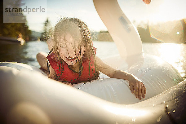 Mädchen spielt auf aufblasbarem Schwan im See