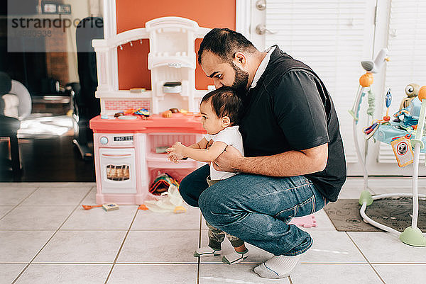 Vater kauert mit dem kleinen Sohn in der Küche