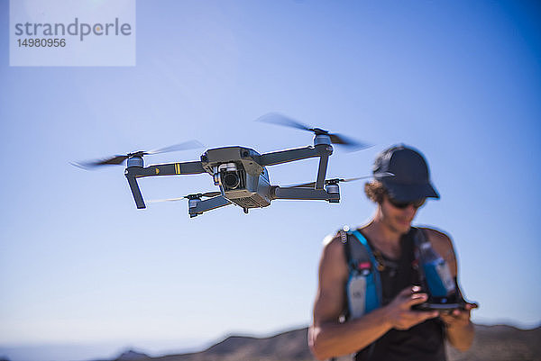 Mann operiert Drohne (unbemanntes Luftfahrzeug) gegen den blauen Himmel  Nelson  Nevada  USA