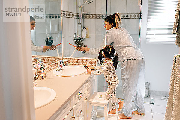 Mädchen und Mutter machen sich im Badezimmer fertig