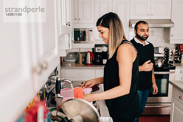 Mittleres erwachsenes Paar in der Küche beim Geschirrspülen
