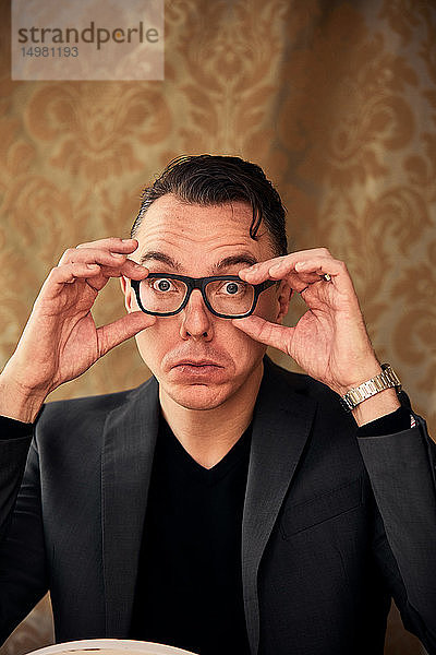 Komiker  der eine Brille für klareres Sehen anpasst