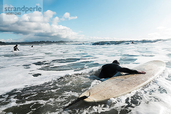 Junger männlicher Surfer mit Surfbrett im Pazifischen Ozean  Rückansicht  Arcata  Kalifornien  Vereinigte Staaten