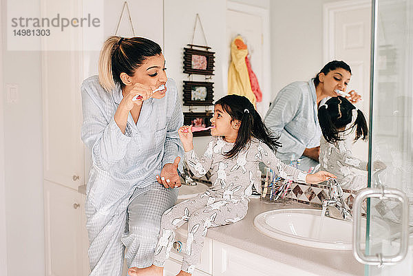 Mädchen und Mutter beim Zähneputzen im Badezimmer