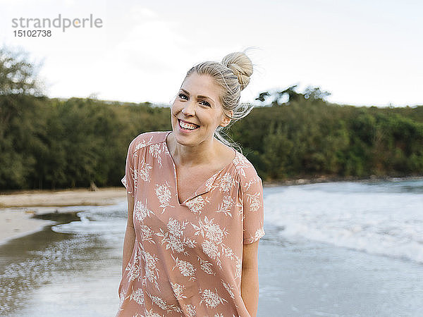 Frau in geblümtem Kleid am Strand