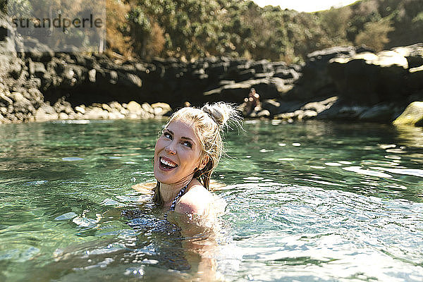 Lächelnde Frau schwimmt im Meer