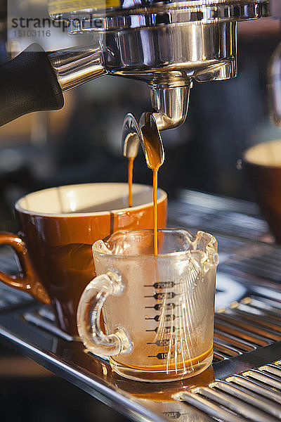 Ausgießen des Kaffees aus dem Siebträger in die Kaffeetasse und den Becher