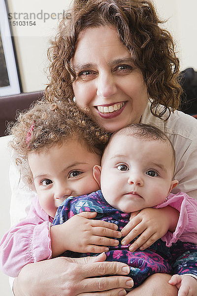 Lächelnde Frau hält ihre beiden Töchter
