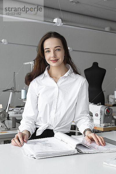 Modedesigner bei der Arbeit am Schreibtisch im Atelier
