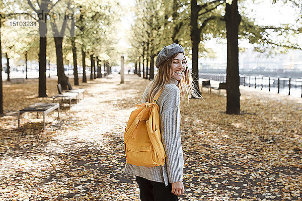 Junge Frau mit gelbem Rucksack im Park in Berlin  Deutschland