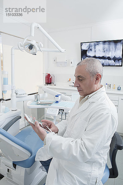 Zahnarzt mit digitalem Tablet in der Zahnarztpraxis