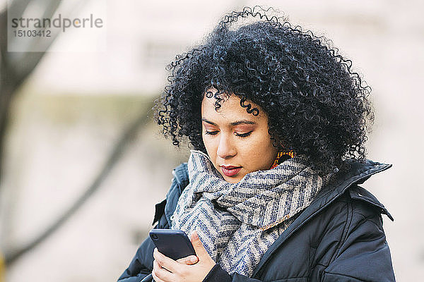 Junge Frau schreibt eine SMS auf einem Smartphone