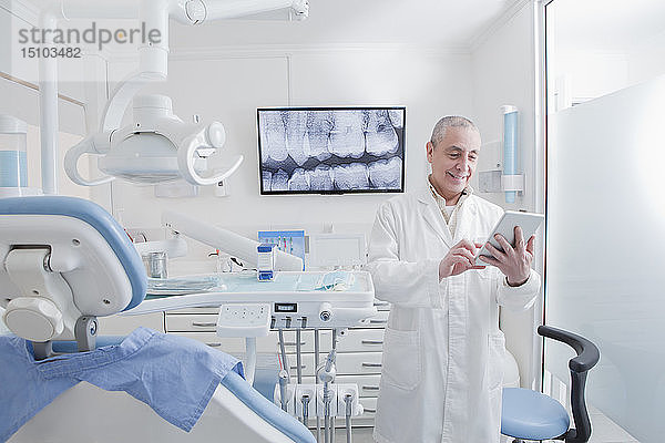 Zahnarzt mit digitalem Tablet in der Zahnarztpraxis