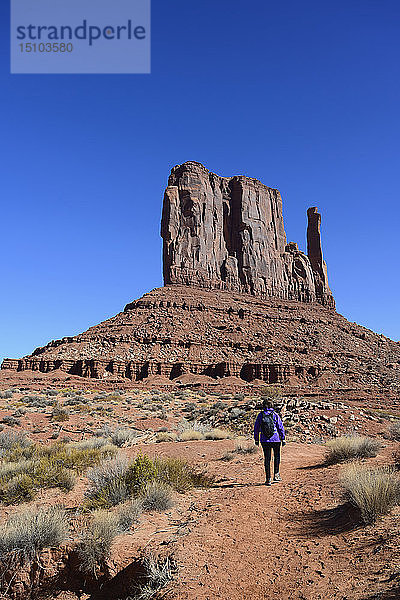 Frau beim Wandern an einem Felsvorsprung im Monument Valley  Arizona  USA