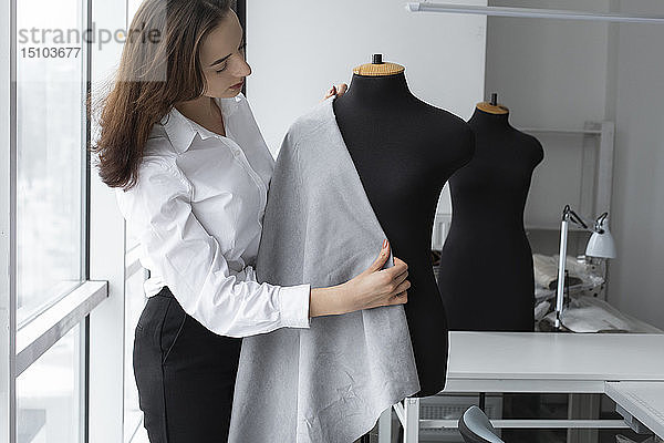 Modedesigner bei der Arbeit mit einem Schneidermodell im Atelier