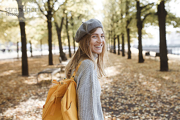 Junge Frau mit gelbem Rucksack im Park in Berlin  Deutschland