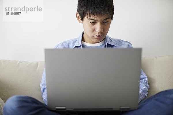Japanischer Teenager mit Laptop