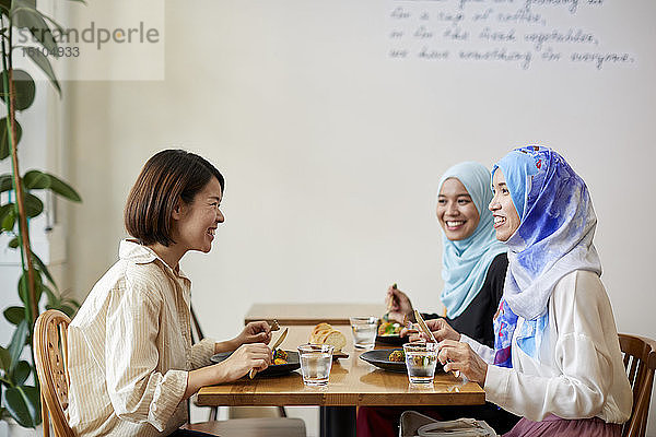 Junge südostasiatische Frauen beim Essen im Restaurant