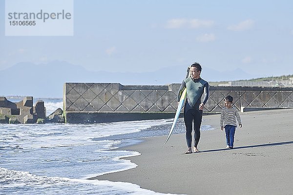 Japanisches Kind mit Vater am Strand