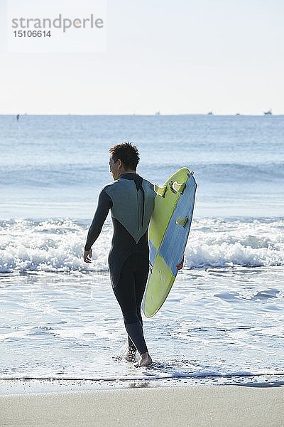 Japanischer Surfer am Strand