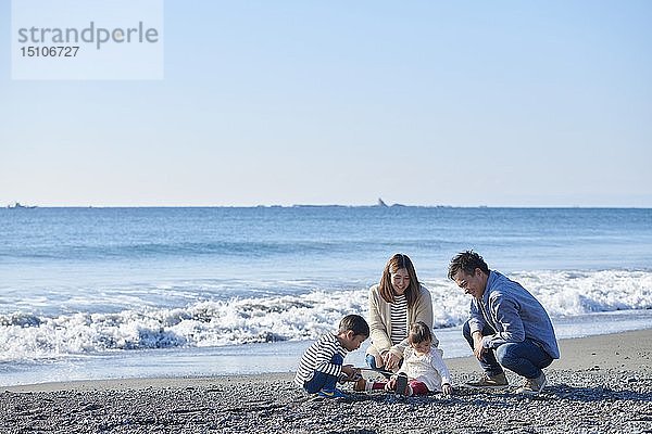 Japanische Familie am Strand