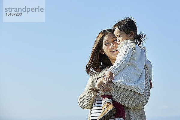 Japanisches Kind mit Mutter am Strand