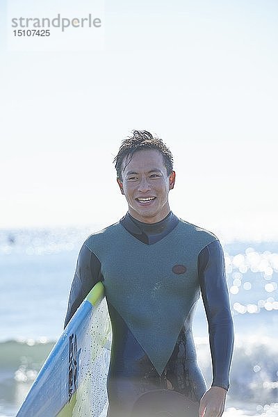 Japanischer Surfer am Strand