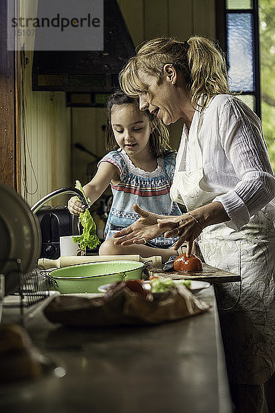Reife Frau unterrichtet ihre Enkelin in der Küche