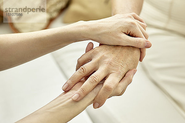 Krankenschwester hält die Hand des Patienten