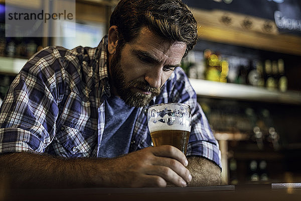 Trauriger Mann sitzt in einer Bierbar