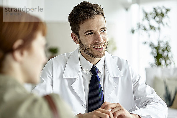 Lächelnder Arzt im Gespräch mit einem Patienten