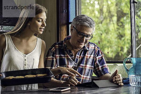 Vater und Tochter benutzen ein digitales Tablet