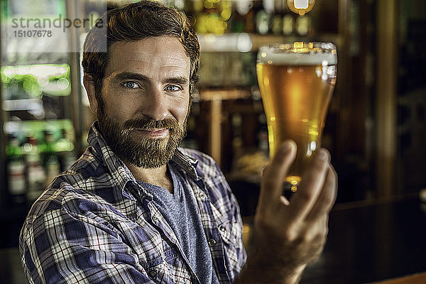 Lächelnder Mann hält ein Bierglas
