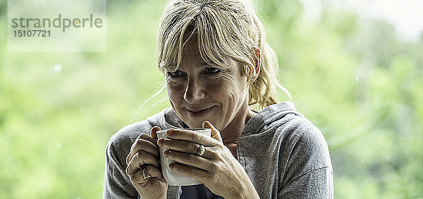 Reife Frau beim Kaffee trinken