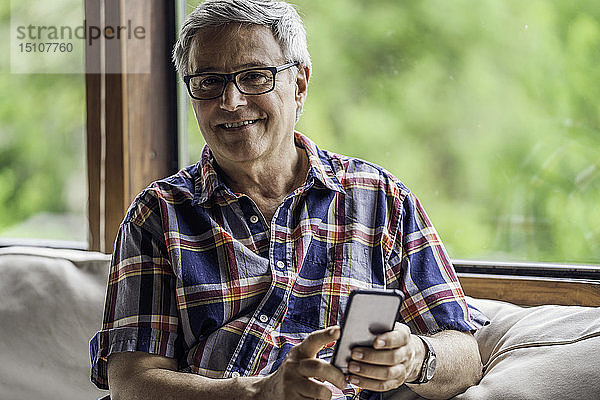 Porträt eines reifen Mannes mit Smartphone