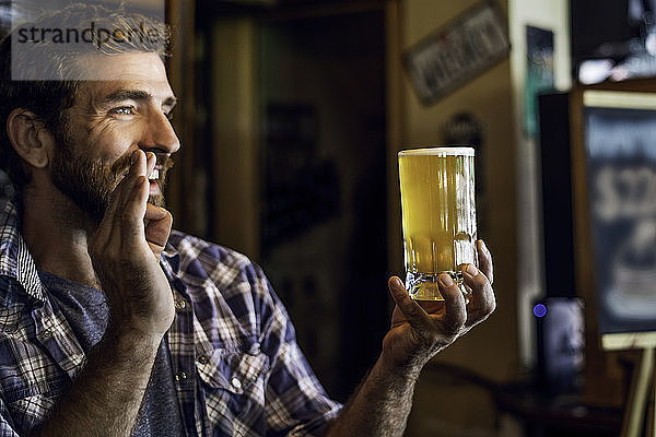 Mann mit Bierkrug zeigt ein Handzeichen