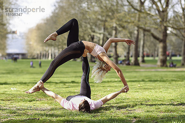 Junges Paar macht Yoga-Akrobatik in einem städtischen Park