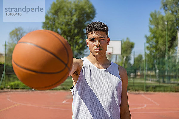 Junger Mann spielt Basketball  gibt dem Basketball