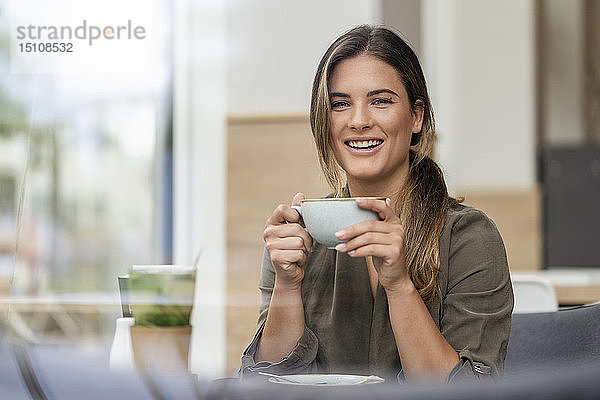 Junge Geschäftsfrau mit Kaffeetasse in einem Cafe