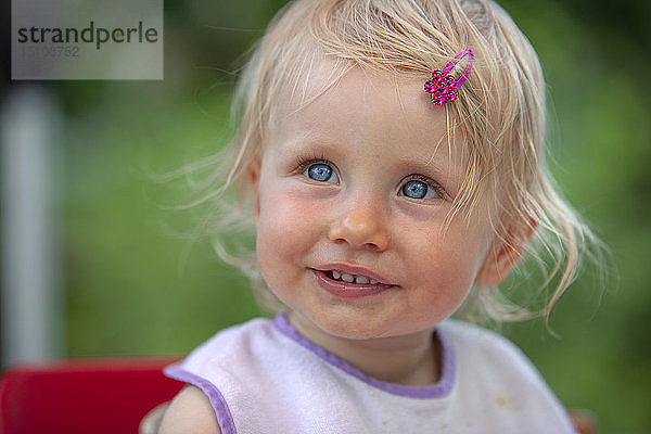 Bildnis eines blonden kleinen Mädchens mit Lätzchen und rosa Haipin