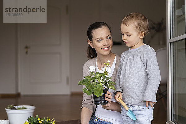 Mutter und Tochter pflanzen zu Hause gemeinsam Blumen