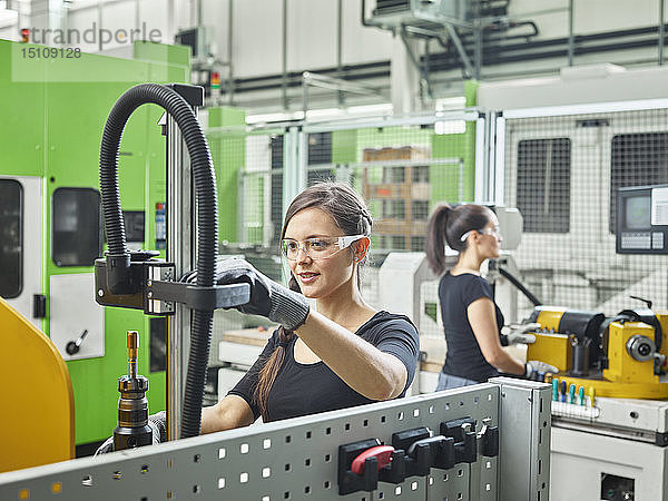 Zwei Frauen arbeiten an Maschinen